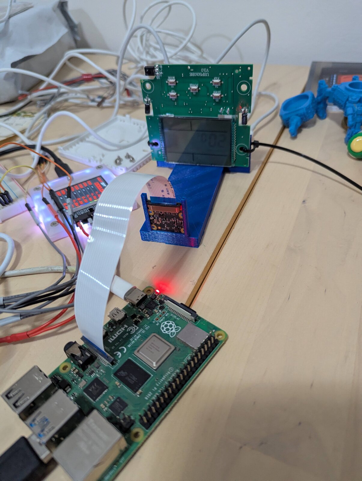 The contraption: rpi camera pointed at the zip-tied panel, Bus Pirate on the breadboard